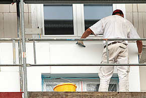Fassadendämmung: Auf dem Bild ist ein Mann auf einem Gerüst.