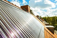 Röhrenkollektor auf Hausdach mit Sonnenreflektion